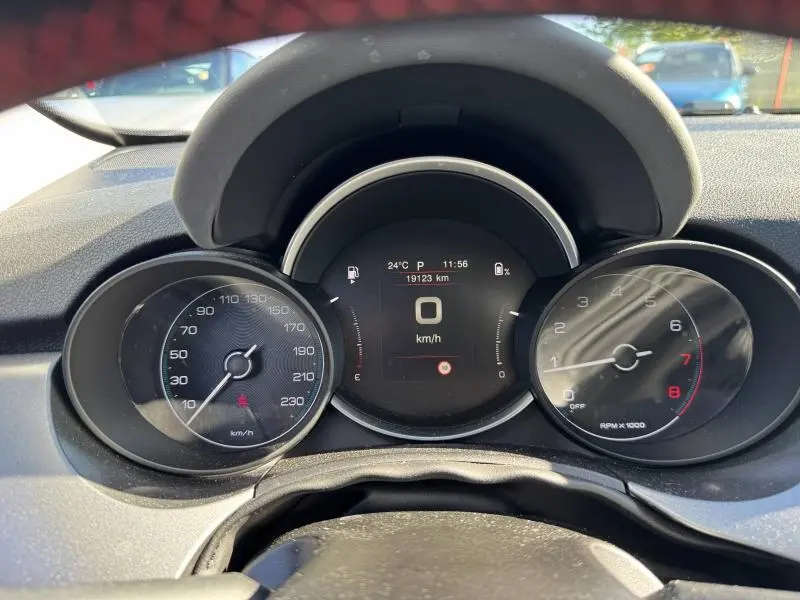 Vue rapprochée du tableau de bord du Fiat 500X 2024, affichage numérique central et compteurs analogiques.