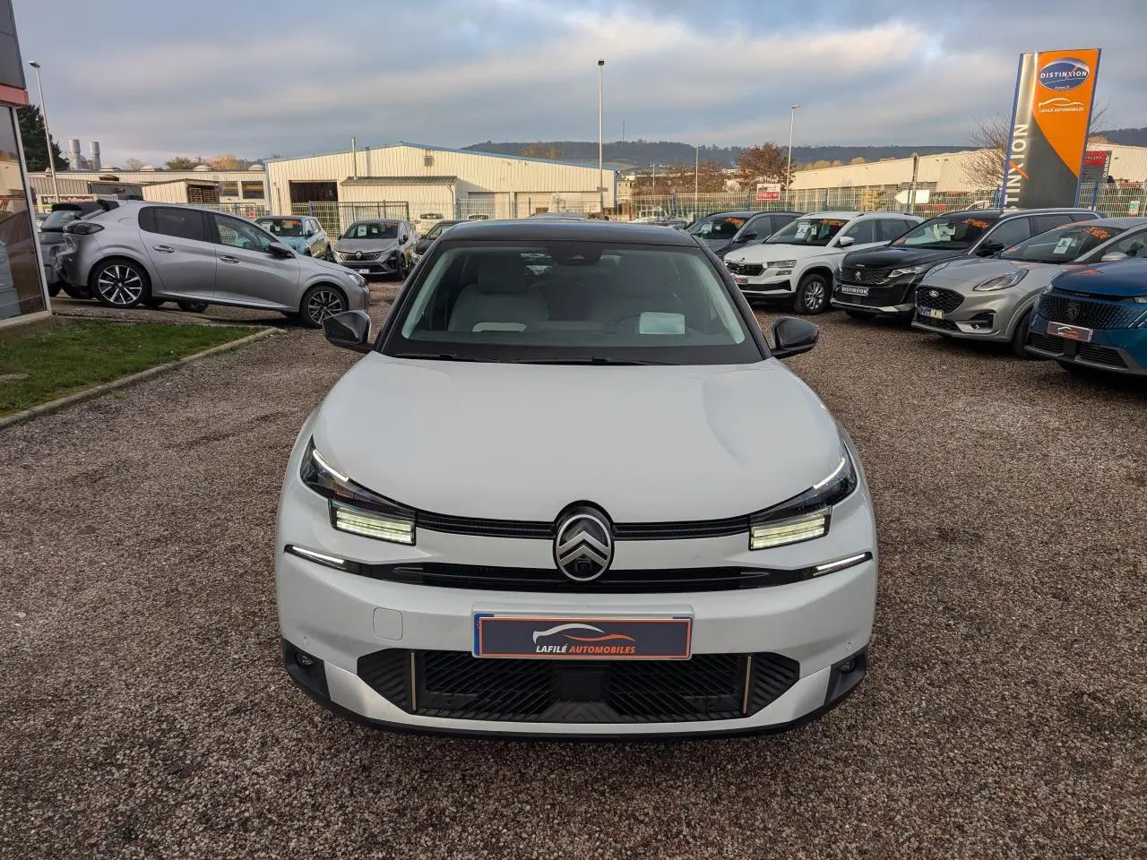 Citroën C4 blanche vue de face avec toit noir bi-ton et signature lumineuse LED distinctive.