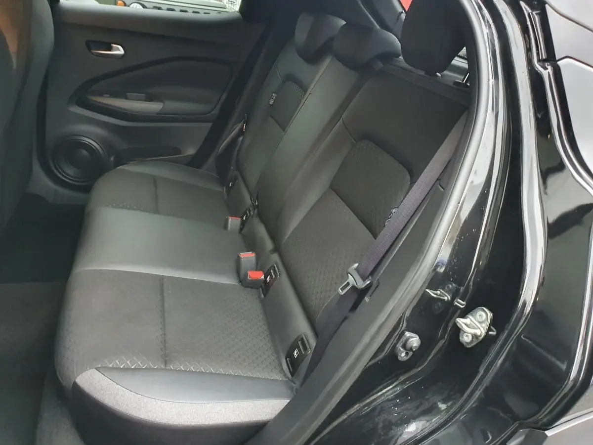 Vue intérieure côté gauche sur la banquette arrière noire du Nissan Juke 2025 avec appuis-tête réglables et ceinture de sécurité.