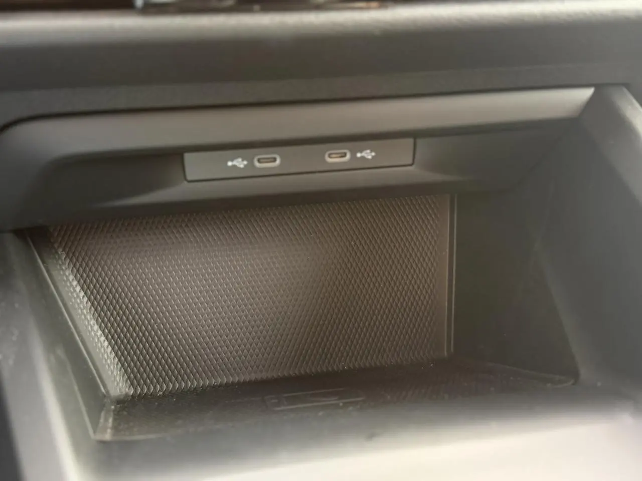 Gros plan sur la console centrale de la Volkswagen Golf 8 gris lunaire, montrant deux ports USB-C intégrés.