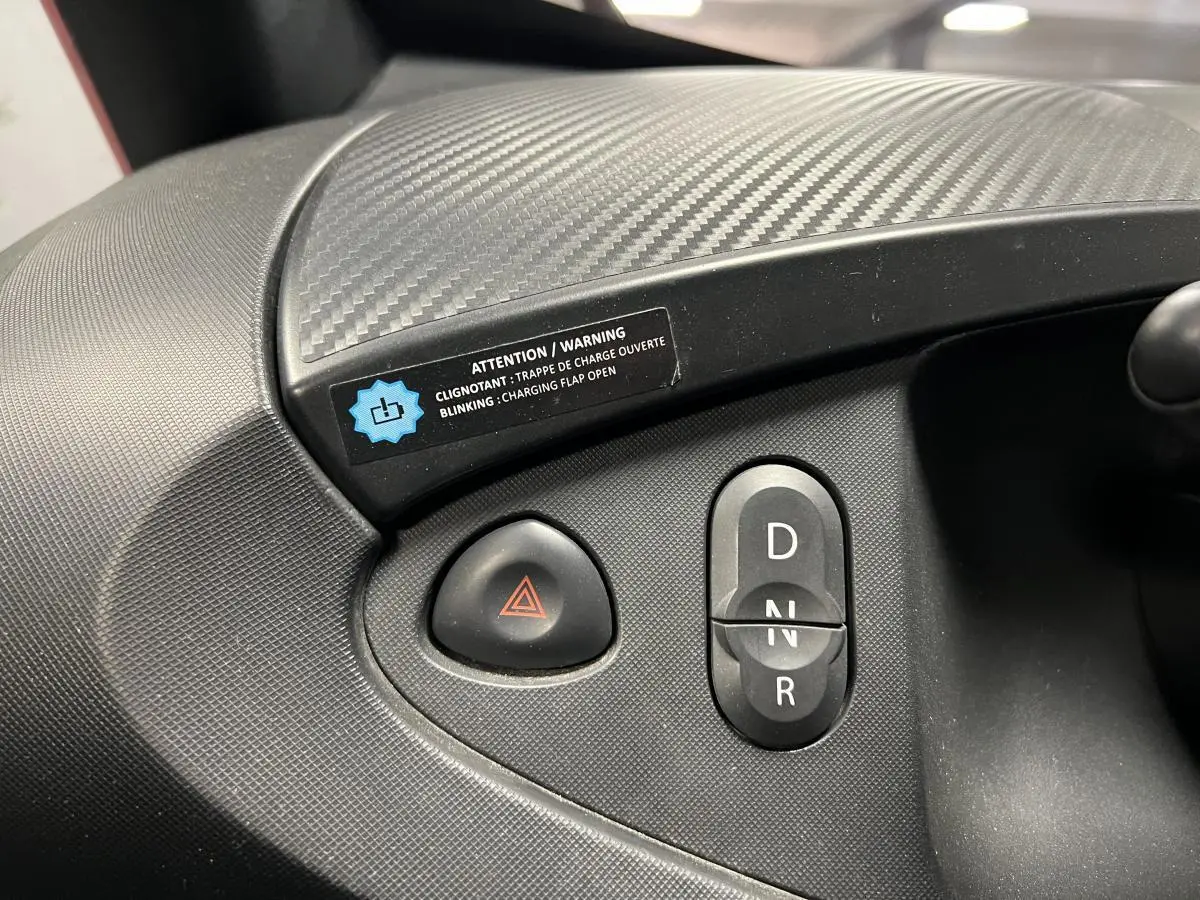 Gros plan sur la console centrale noire de la Renault Twizy Intens 2019 montrant les boutons de feux de détresse et de sélection de vitesse.