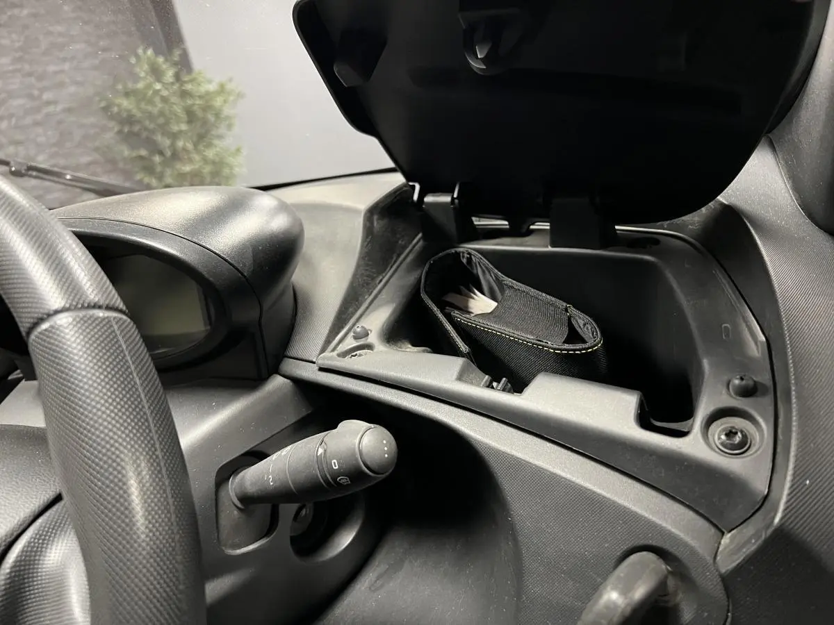 Intérieur Renault Twizy Intens 2019, vue rapprochée du tableau de bord avec boîte à gants ouverte et volant noir texturé.