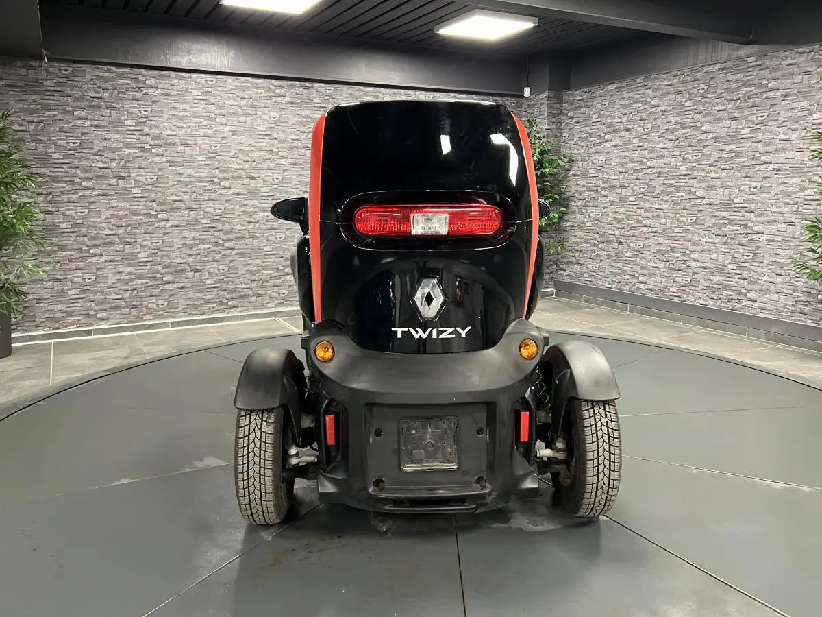 Vue arrière du Renault Twizy Intens 2019 orange et noir avec feux arrière allongés et roues apparentes.