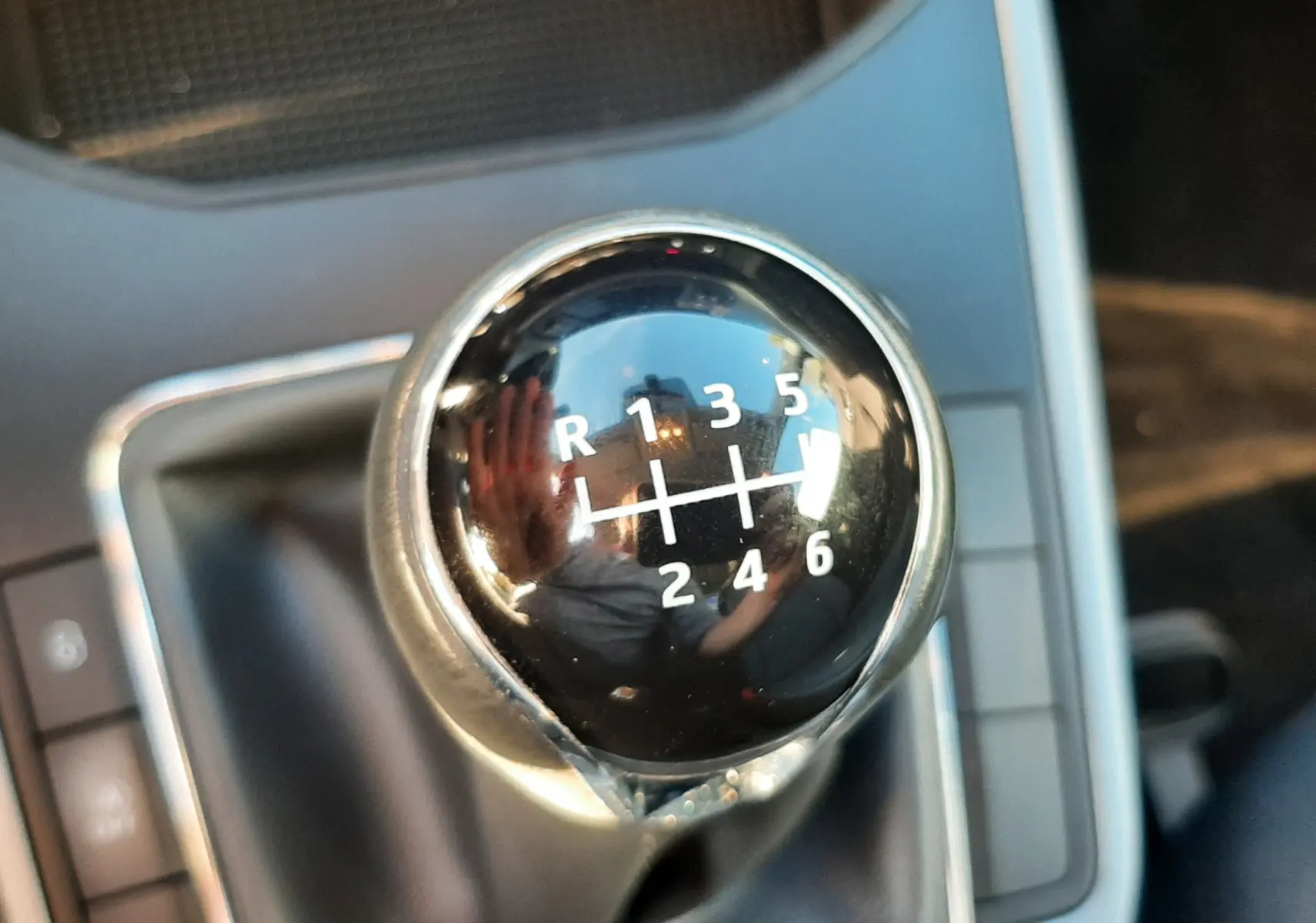 Gros plan sur le levier de vitesses manuel noir du SEAT Arona 2019, détails des rapports visibles sur fond gris.