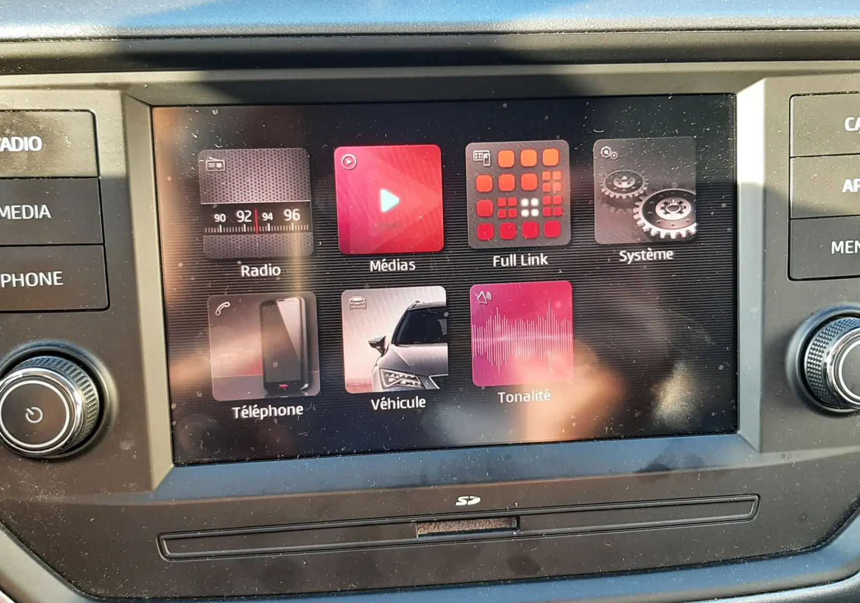 Écran tactile central de la SEAT Arona 2019 affichant les menus multimédia et véhicule, entouré de commandes noires.