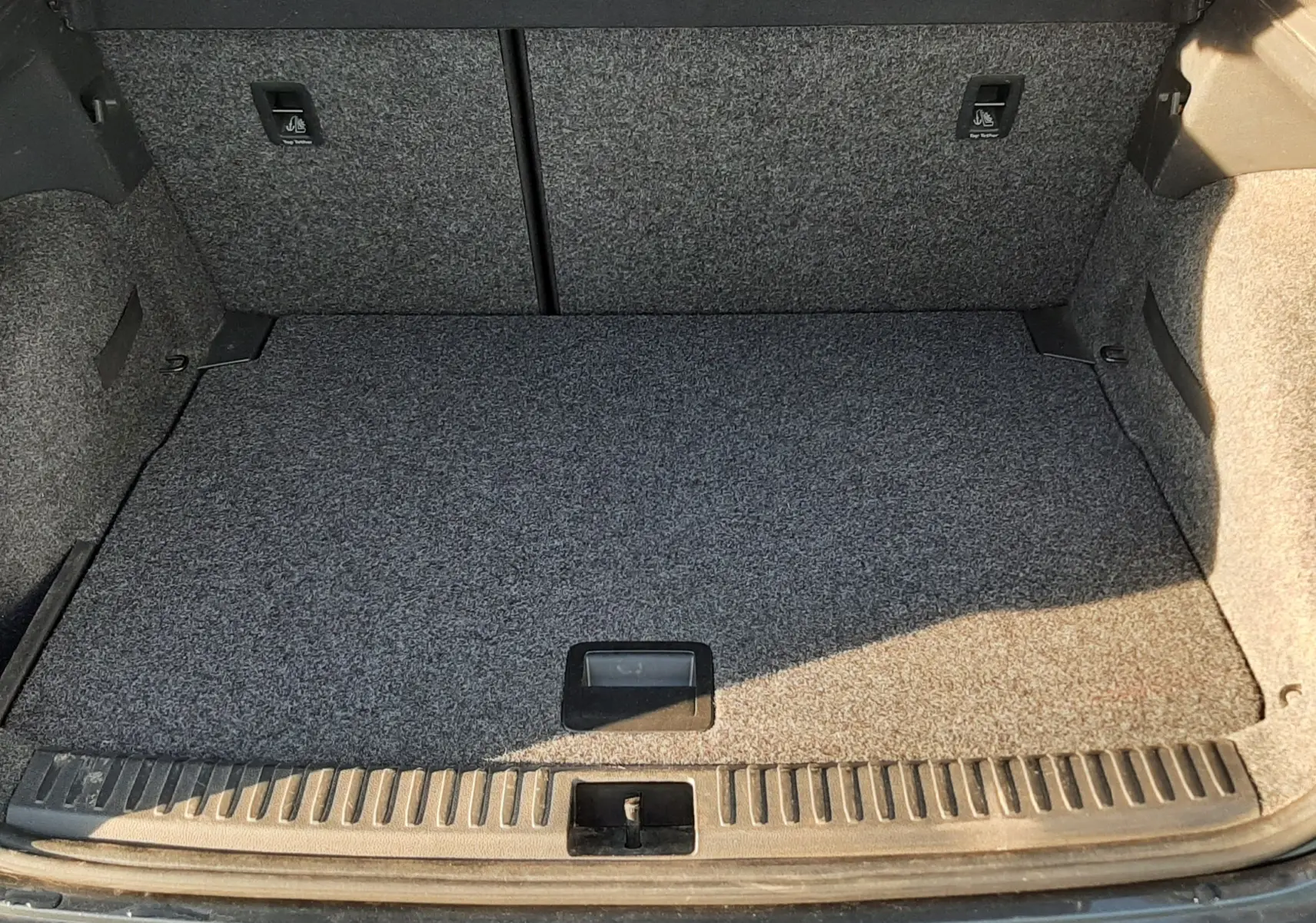 Coffre ouvert vu de l'arrière d'un SEAT Arona gris Magnetic avec toit noir, montrant l'espace de chargement vide.