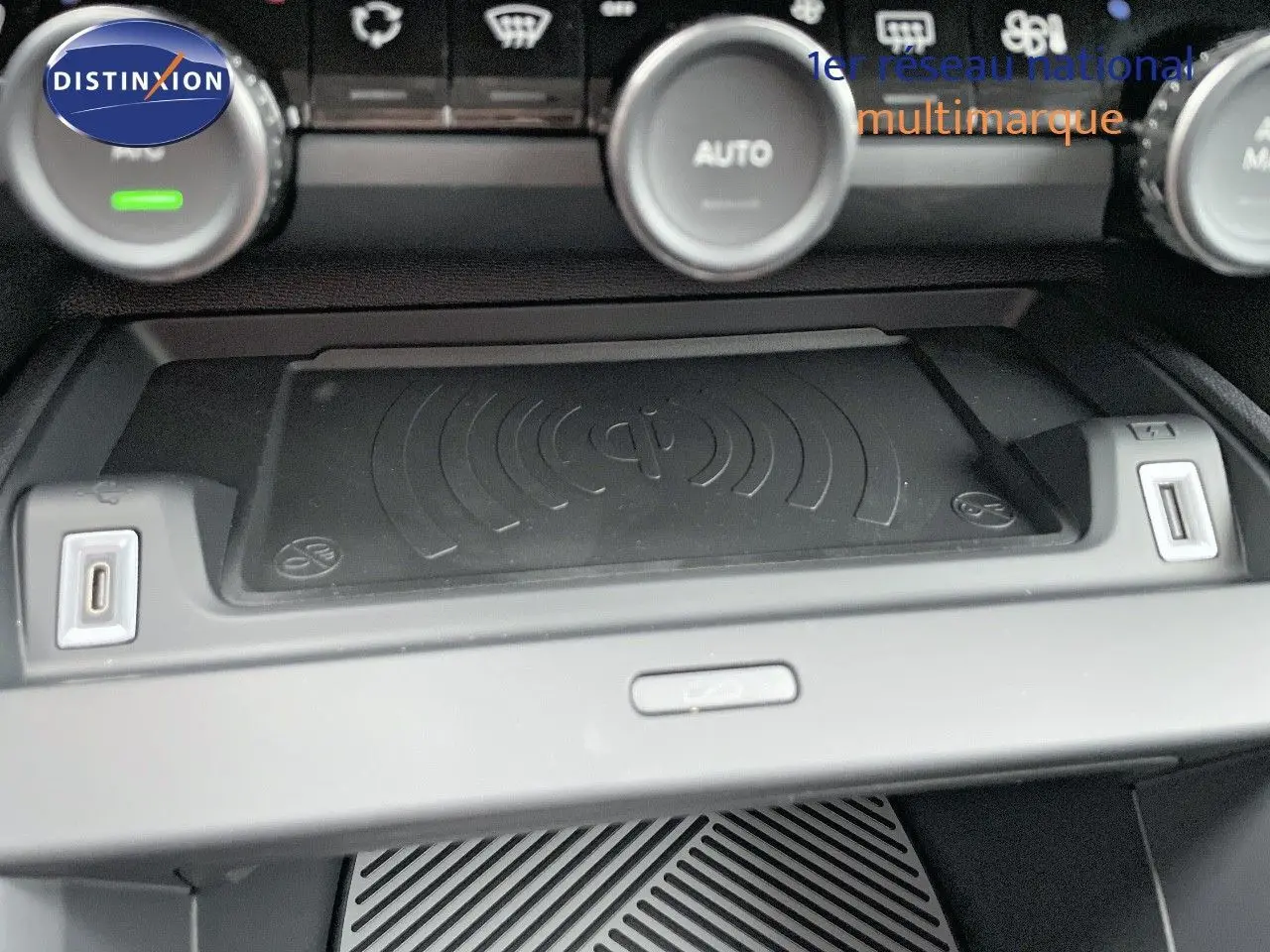Gros plan sur la console centrale de la Citroën C4 2024, avec plateau de recharge sans fil et ports USB visibles.