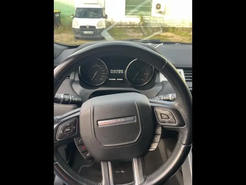 Vue intérieure centrée sur le volant cuir noir du Range Rover Evoque 2.2 Td4 Dynamic de 2013, avec tableau de bord visible.