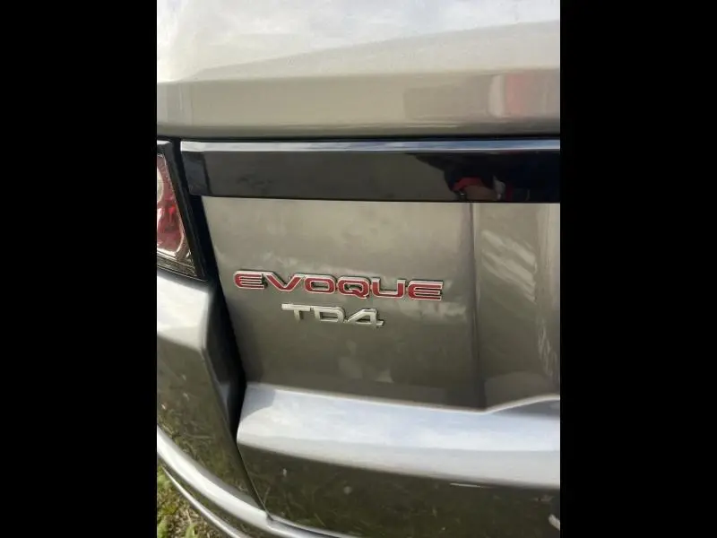 Gros plan sur l'arrière gris Orkney du Range Rover Evoque 2.2 Td4 avec logo Evoque rouge et Td4 argenté.