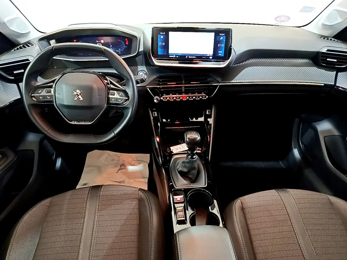 Intérieur de la Peugeot 208 PureTech 100 S&S Allure Business 2020, vue frontale du tableau de bord et volant cuir noir.