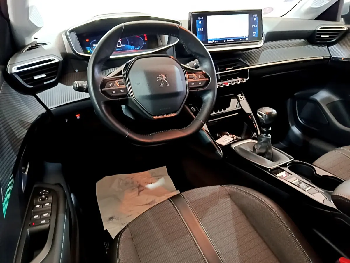 Intérieur de la Peugeot 208 PureTech 100 S&S Allure Business 2020, vue cockpit avec volant cuir et écran tactile central.