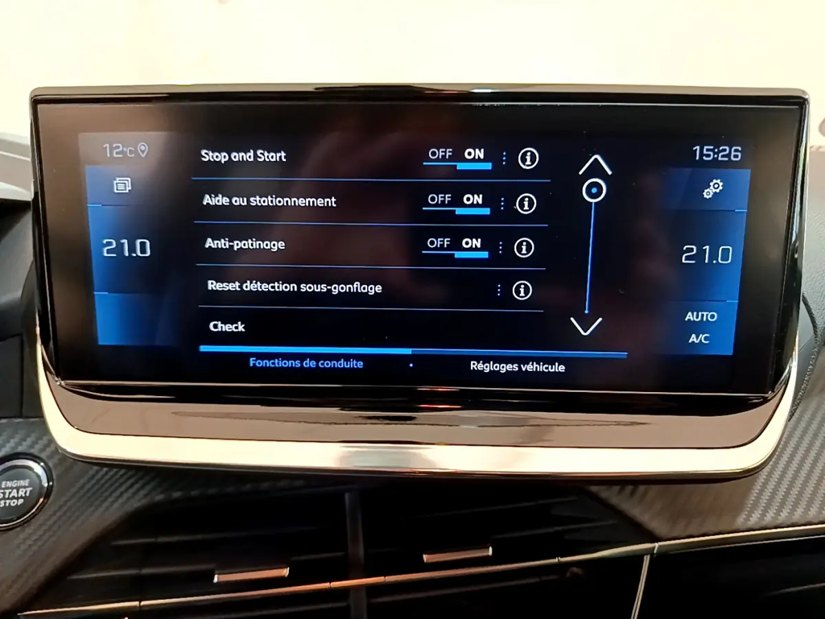 Écran tactile central affichant les réglages de conduite dans l'habitacle d'une Peugeot 208 gris clair de 2020.