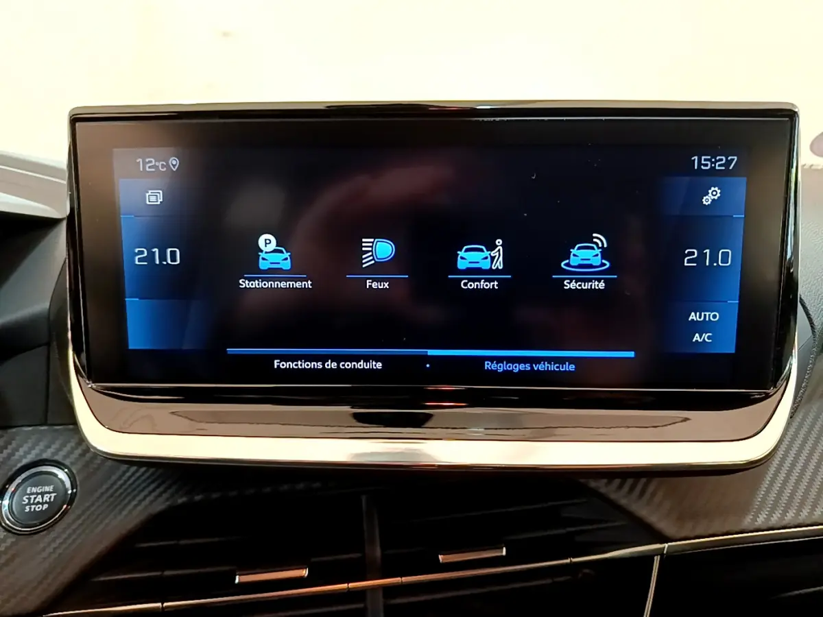 Écran tactile central affichant les réglages du véhicule dans une Peugeot 208 gris clair, vue intérieure frontale.