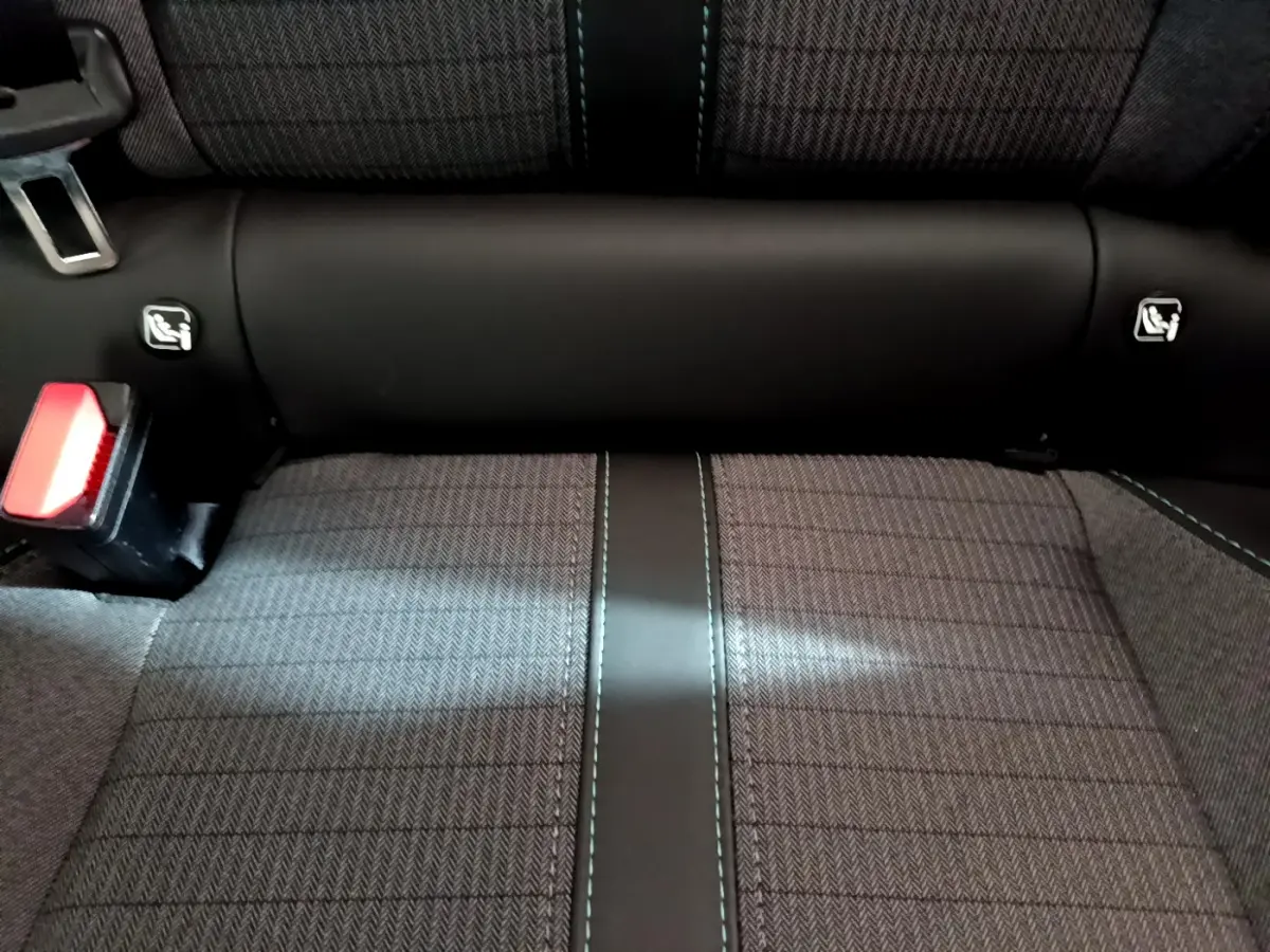 Gros plan sur la banquette arrière grise de la Peugeot 208 avec ceintures et fixations Isofix visibles.