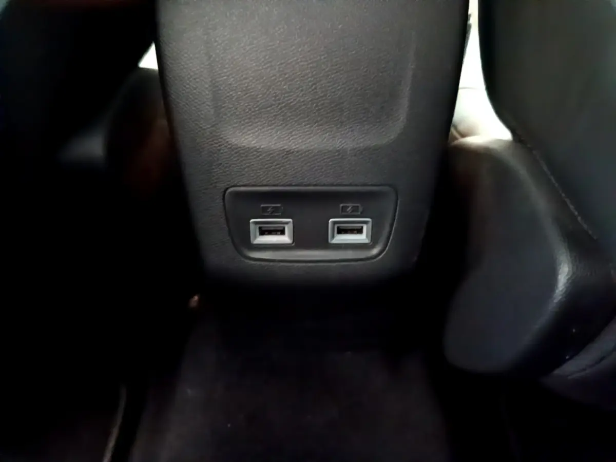 Gros plan sur les deux ports USB arrière intégrés au panneau central noir de la Peugeot 208 gris clair.