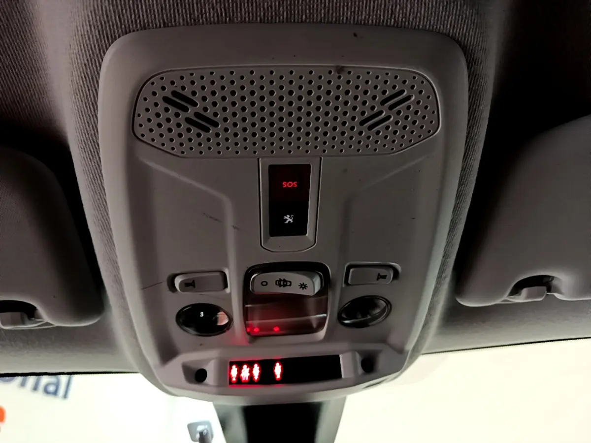Vue en contre-plongée du plafonnier gris clair de la Peugeot 208 avec bouton SOS et commandes d’éclairage intégrées.