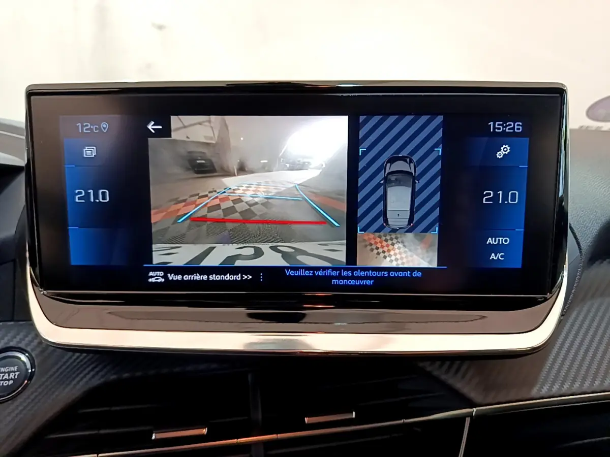 Écran tactile central de la Peugeot 208 gris clair affichant la caméra de recul et la température intérieure à 21°C.