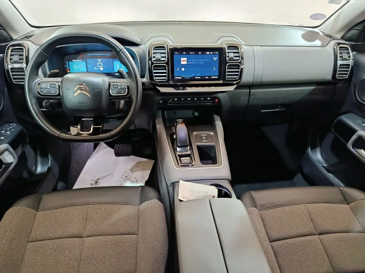 Vue intérieure avant du Citroën C5 Aircross Hybrid 225 avec tableau de bord numérique et console centrale moderne.