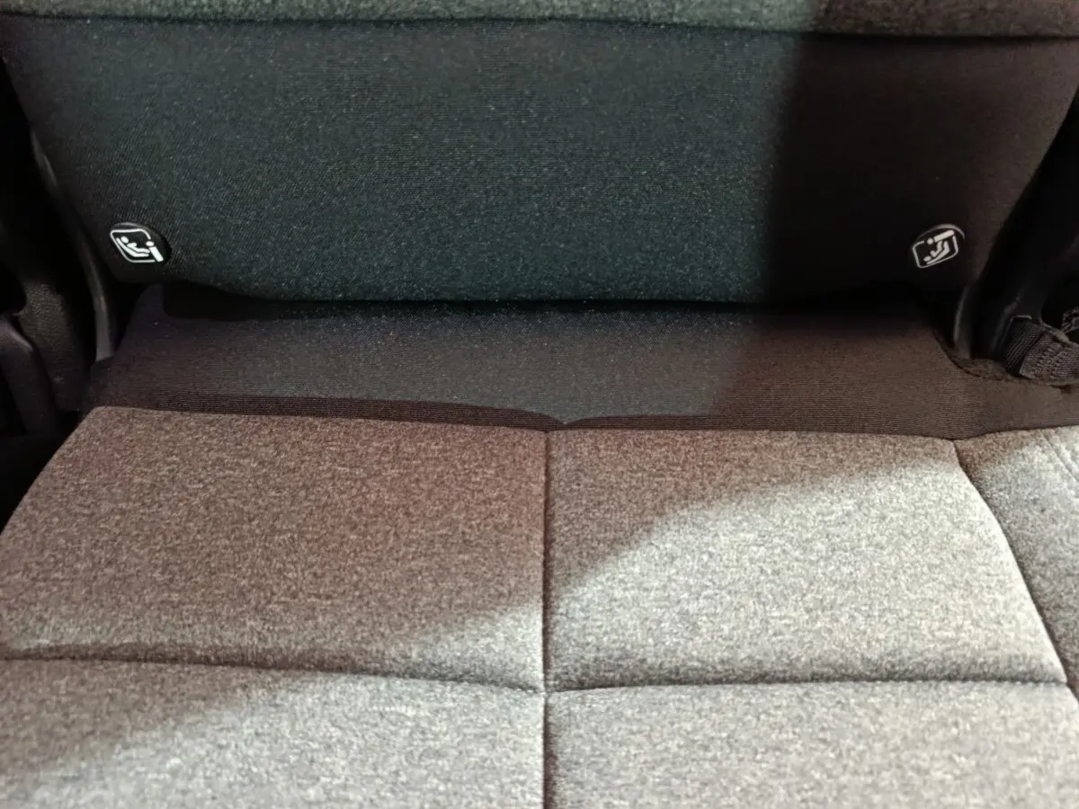 Détail de la banquette arrière rabattue en tissu gris du Citroën C5 Aircross Hybrid blanc, vue intérieure rapprochée.
