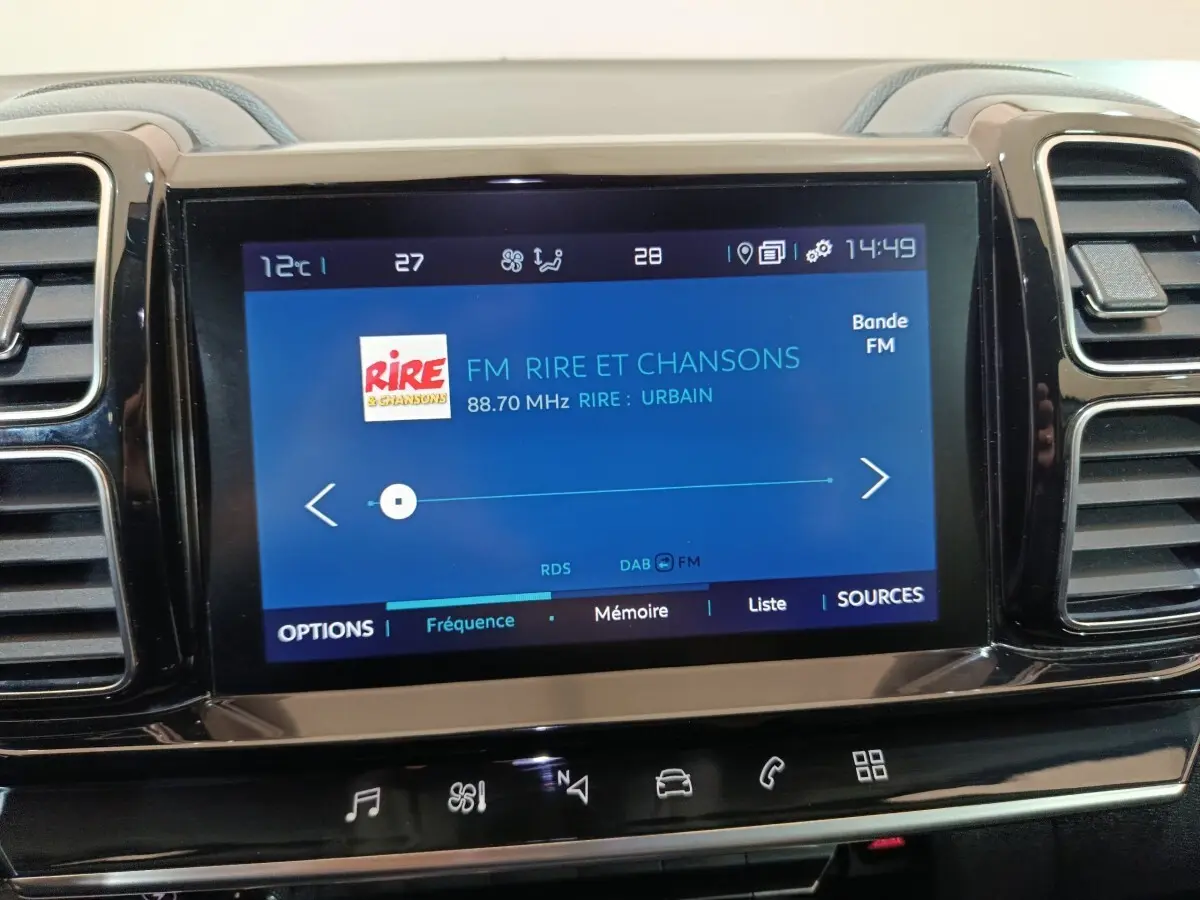 Écran tactile central du tableau de bord du Citroën C5 Aircross Hybrid blanc, affichant la radio FM.