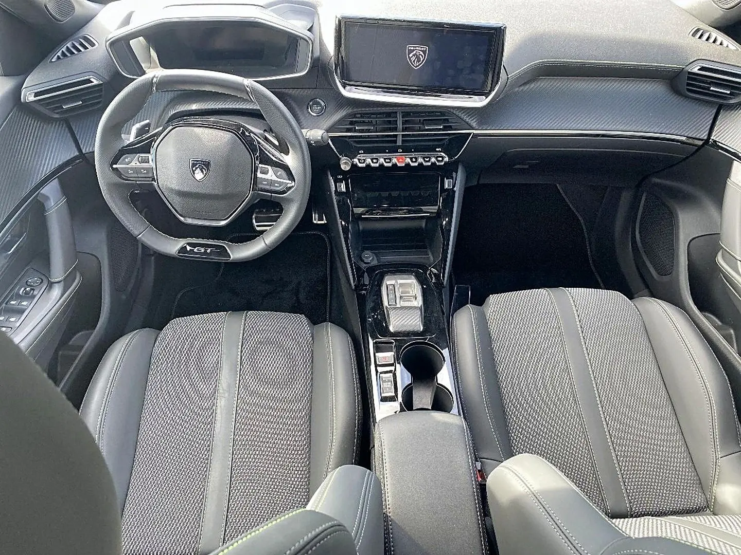 Vue intérieure avant du Peugeot 2008 noir 2025, avec volant GT, écran tactile et sellerie cuir tissu gris.