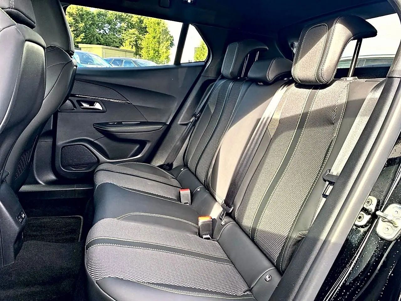 Vue intérieure côté droit des sièges arrière noirs en tissu et cuir du Peugeot 2008 1.2 hybrid 145 GT 2025.