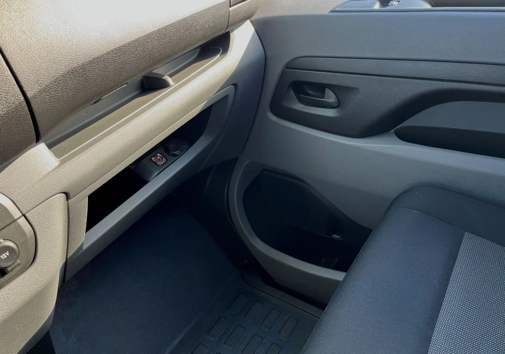 Intérieur côté passager du Citroën Jumpy 2022, avec tableau de bord et porte en plastique gris clair et siège tissu noir.
