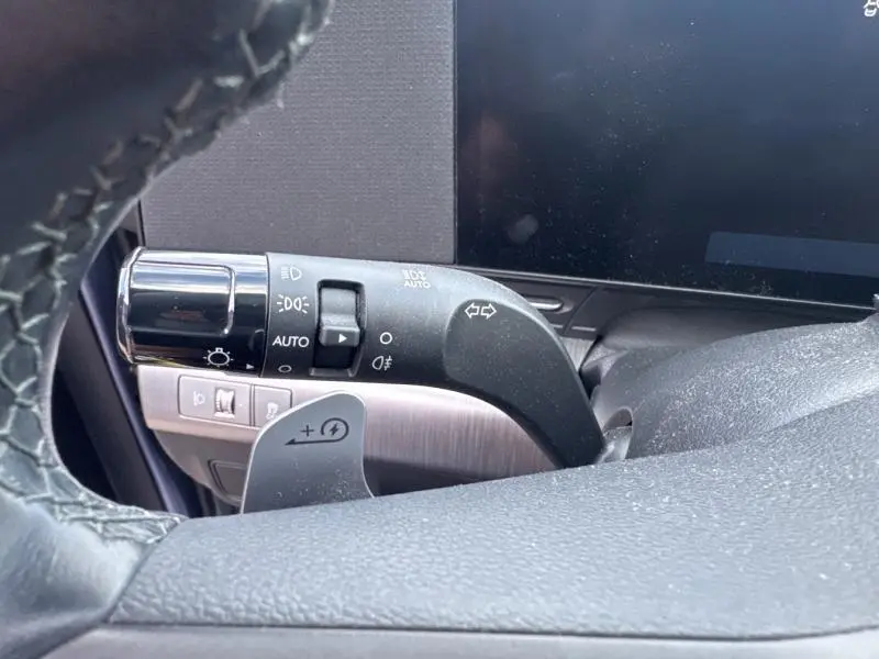 Gros plan sur la commande des phares et clignotants à gauche du volant du Hyundai KONA Electric bleu métallisé 2023.