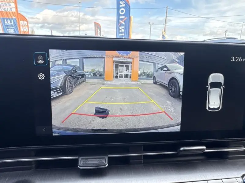 Vue caméra de recul du Hyundai KONA Electric 2023 Metal Blue, montrant l'arrière avec marquages de guidage colorés.