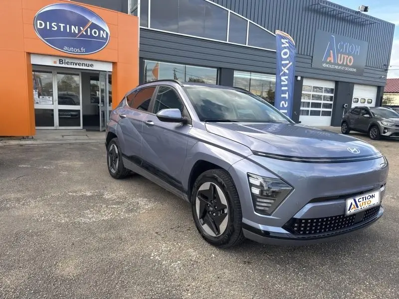 Vue 3/4 avant droit d'un Hyundai KONA Electric 2023 métallisé Metal Blue, avec jantes alu et phares LED distinctifs.