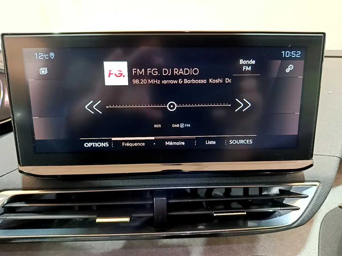 Écran tactile central affichant la radio FM dans l'habitacle du Peugeot 5008 bleu PureTech 2021.