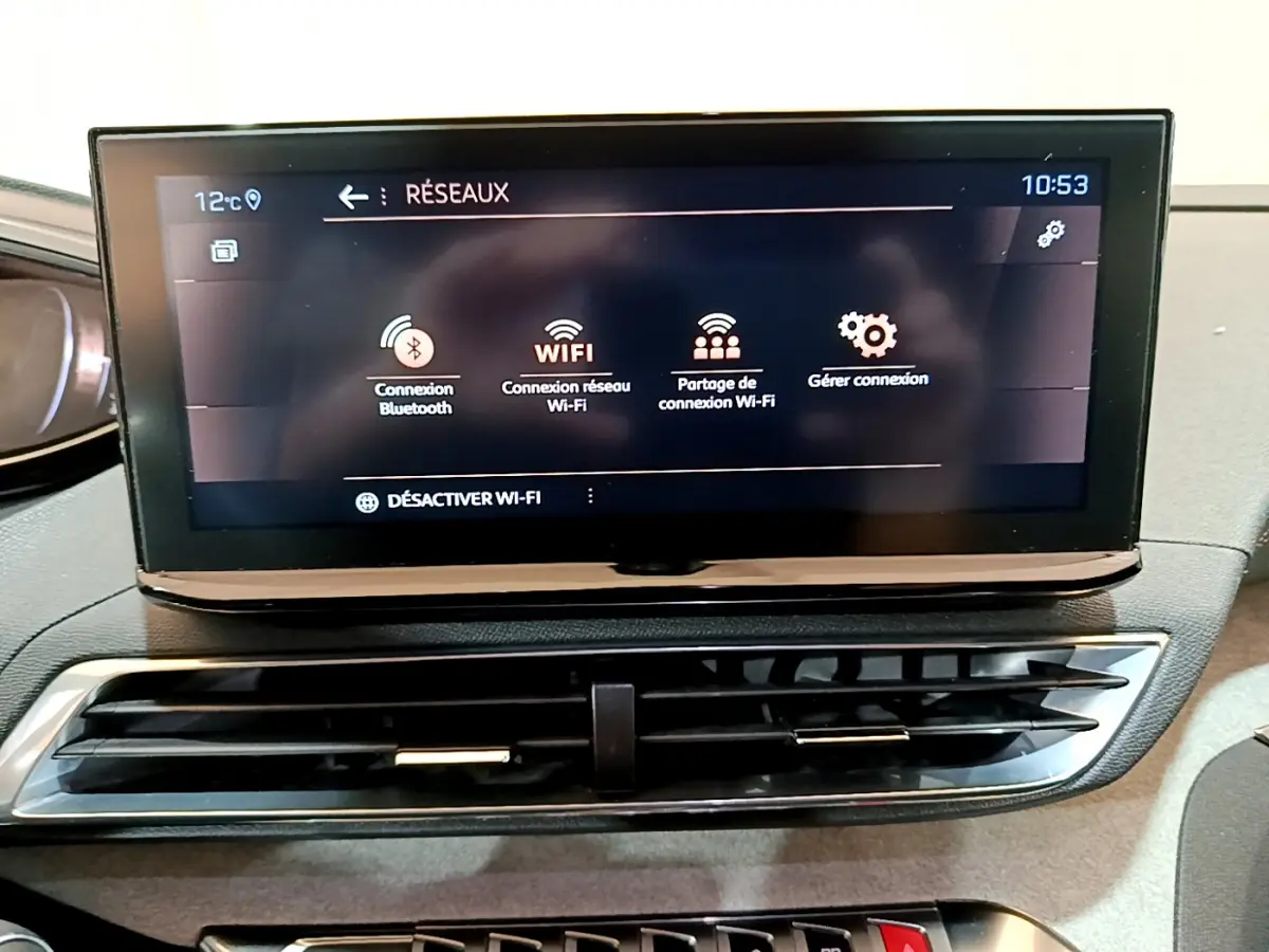Écran tactile central affichant les options Wi-Fi dans l'habitacle du Peugeot 5008 GT bleu, vue frontale rapprochée.