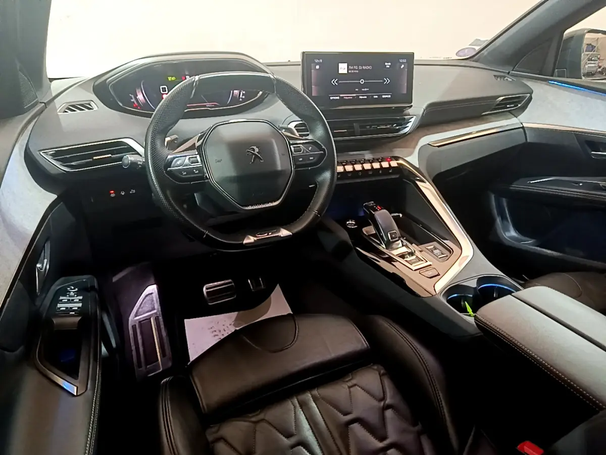 Intérieur noir du Peugeot 5008 GT 2021, vue du poste de conduite avec volant compact et écran tactile central.