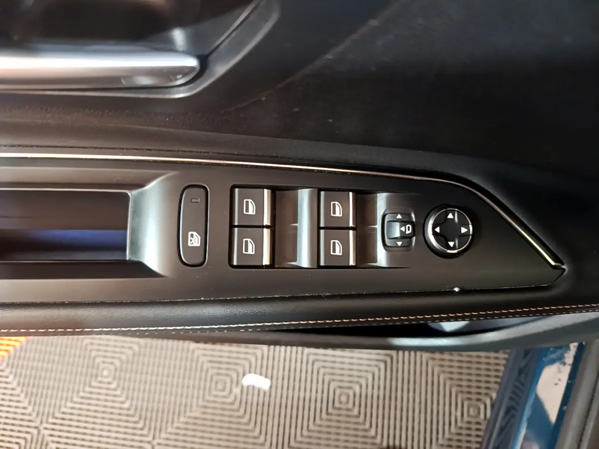 Commande des vitres et réglage des rétroviseurs sur la porte côté conducteur d'un Peugeot 5008 bleu 2021.
