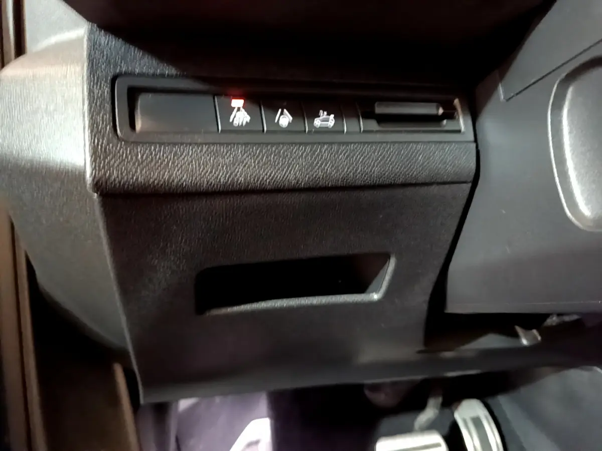 Gros plan sur les commandes sous le tableau de bord côté conducteur du Peugeot 5008 bleu, version GT 2021.