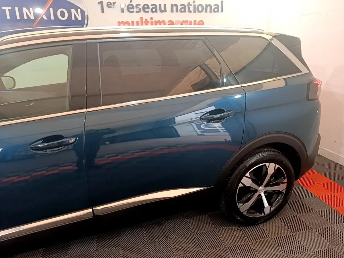 Vue latérale côté droit du Peugeot 5008 bleu 2021 avec jantes alliage et vitres teintées.