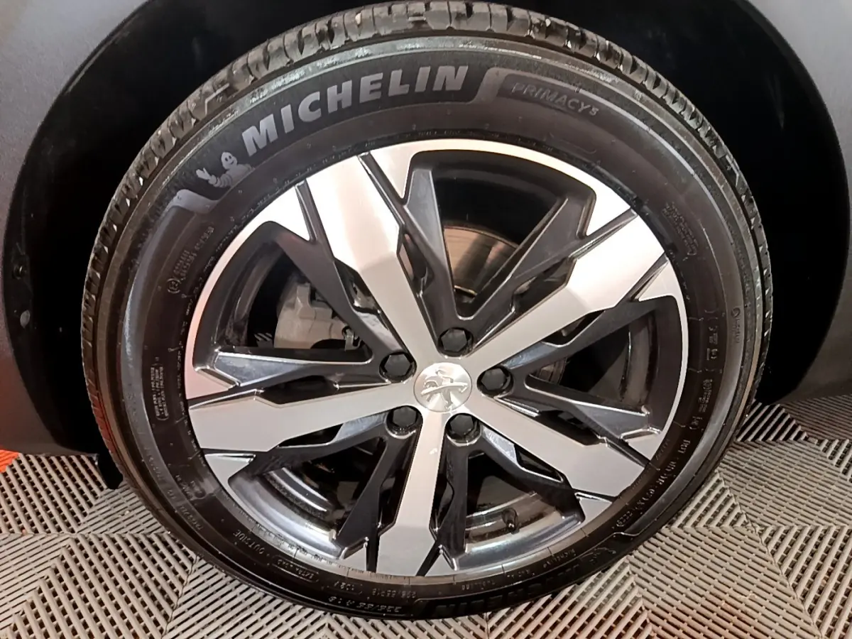 Gros plan sur la jante alliage bicolore et pneu Michelin du Peugeot 5008 PureTech bleu, version GT 2021.