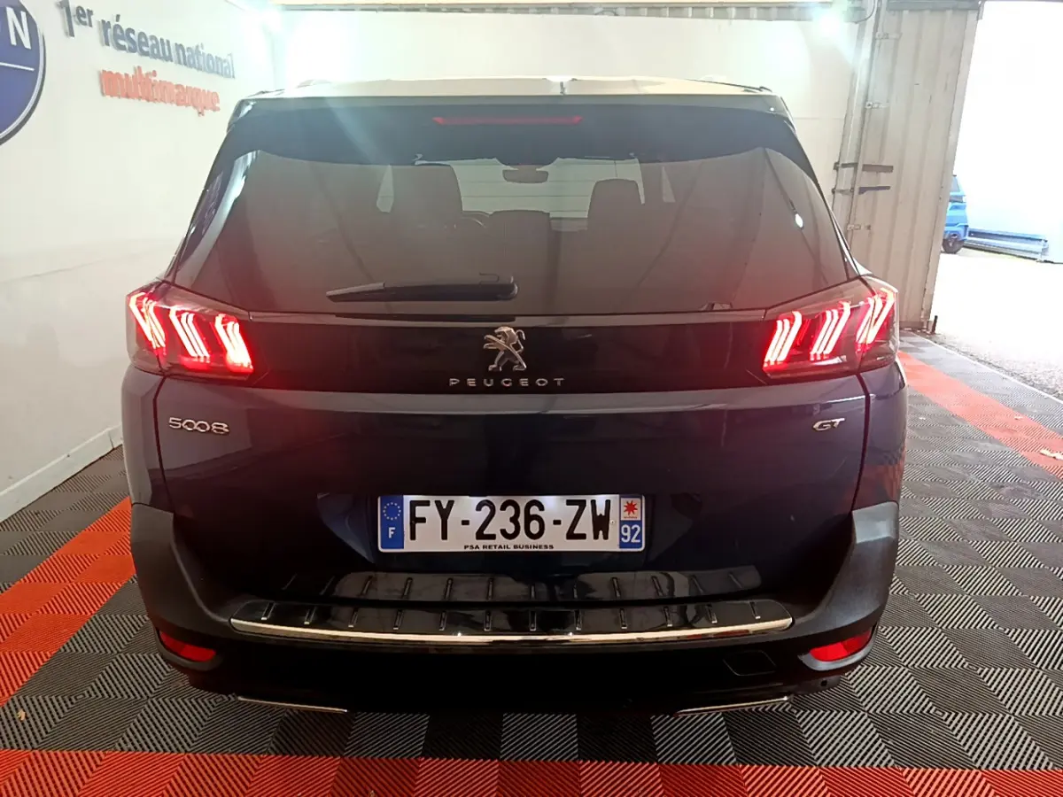 Vue arrière d'un Peugeot 5008 GT bleu avec feux LED caractéristiques et plaque d'immatriculation française.