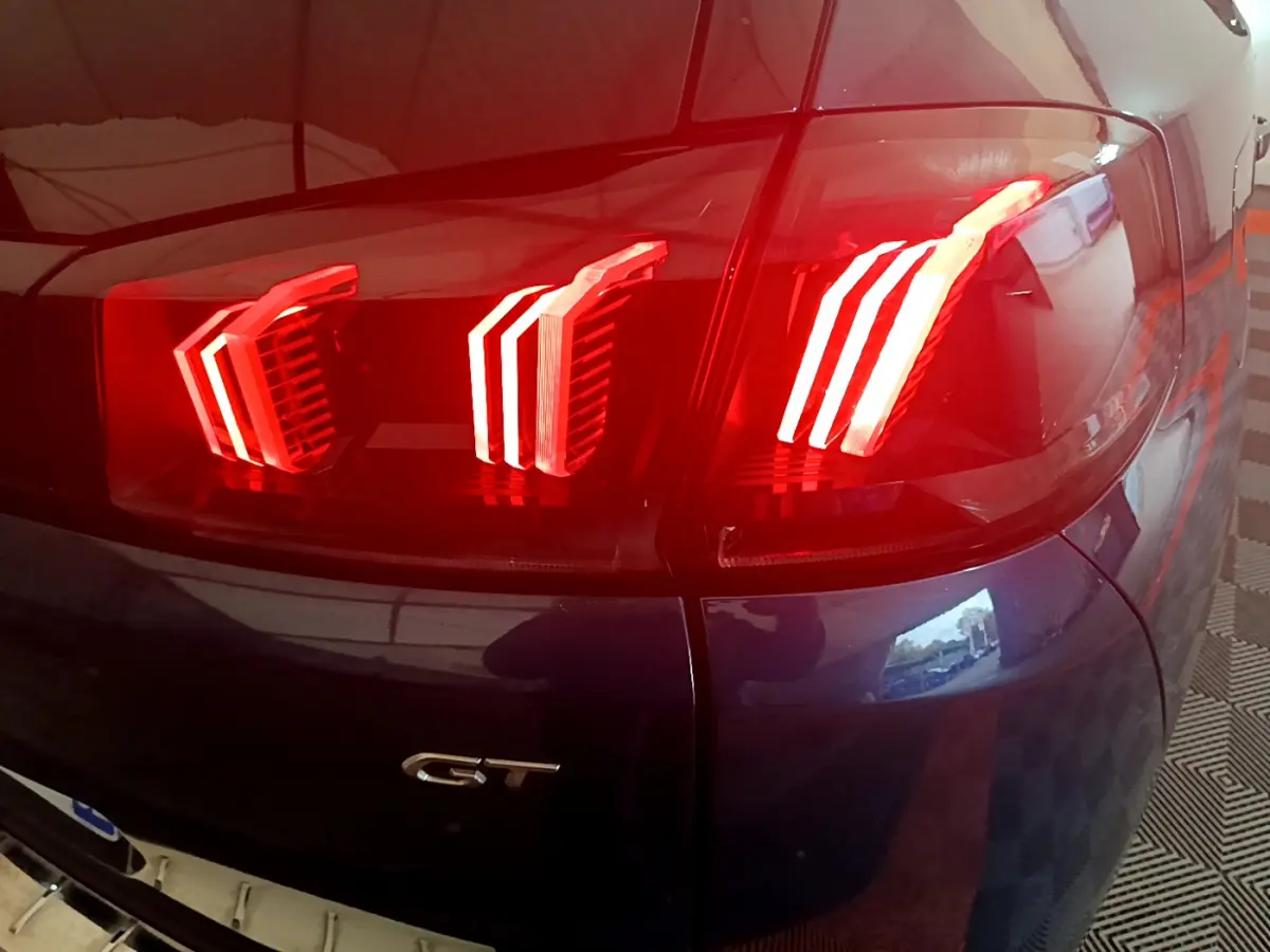 Gros plan sur le feu arrière droit rouge et la carrosserie bleu du Peugeot 5008 GT 2021.