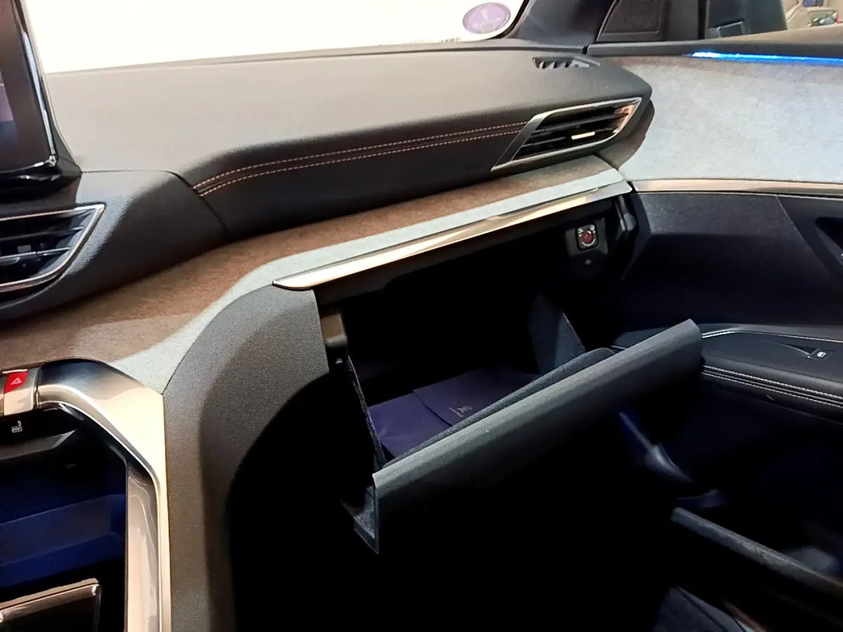 Intérieur Peugeot 5008 GT 2021, vue côté passager sur tableau de bord et boîte à gants ouverte avec surpiqûres orange.