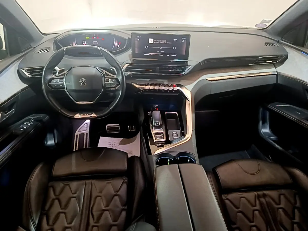 Intérieur noir du Peugeot 5008 GT 2021, vue de face sur le tableau de bord et le volant compact multifonctions.