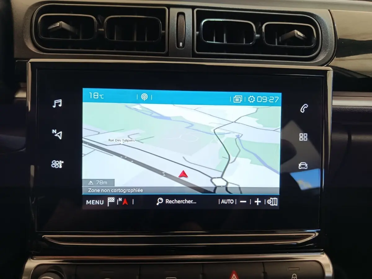 Écran tactile de navigation 7 pouces dans le tableau de bord noir d'une Citroën C3 blanche, vue intérieure rapprochée.