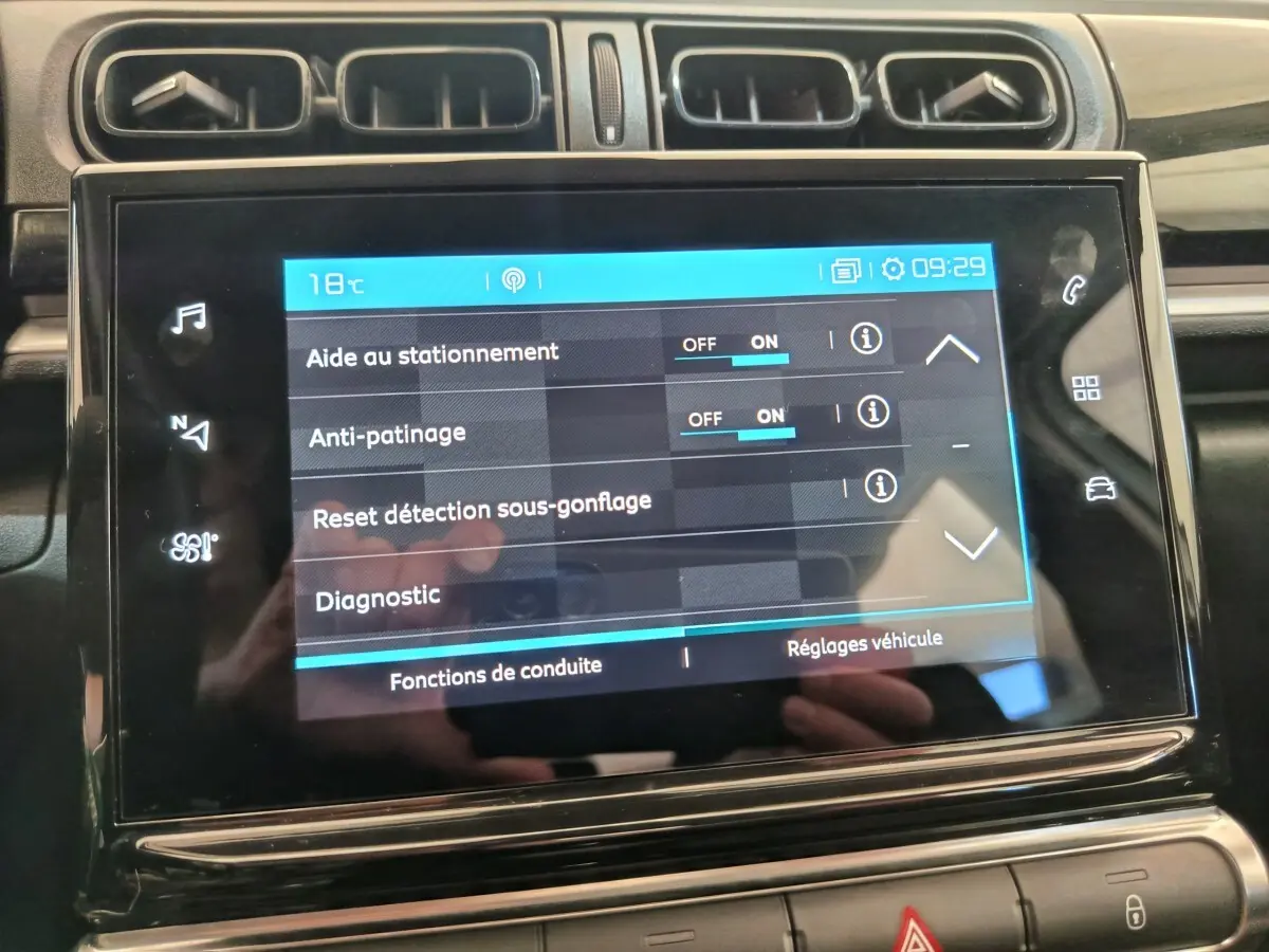 Écran tactile central affichant les réglages d'aide à la conduite dans l'habitacle d'une Citroën C3 blanche.
