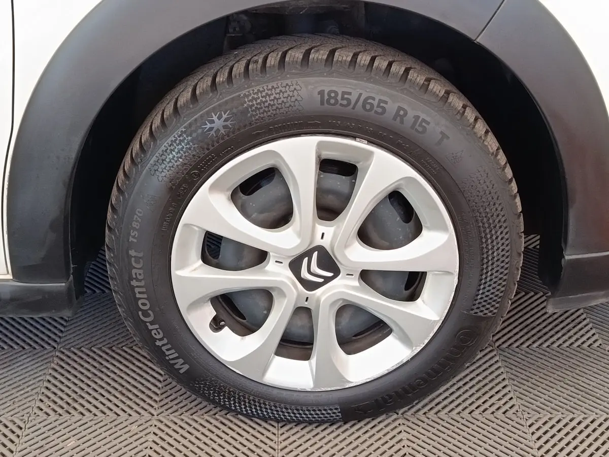 Gros plan sur la roue avant droite d'une Citroën C3 blanche, avec jante en alliage et pneu hiver Continental.