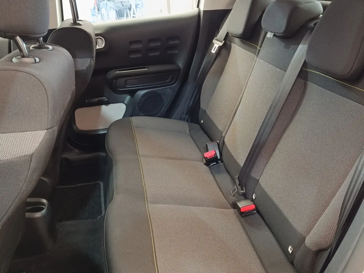 Vue intérieure du siège arrière droit de la Citroën C3 2020, tissu gris avec surpiqûres jaunes et ceintures noires.