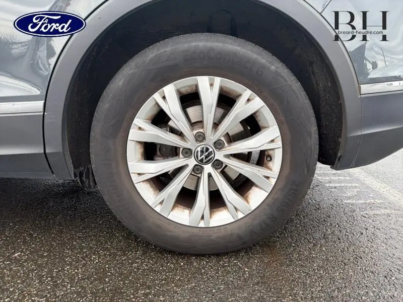 Gros plan sur la roue avant droite du Volkswagen Tiguan gris dauphin métallisé avec jante alu multibranches.