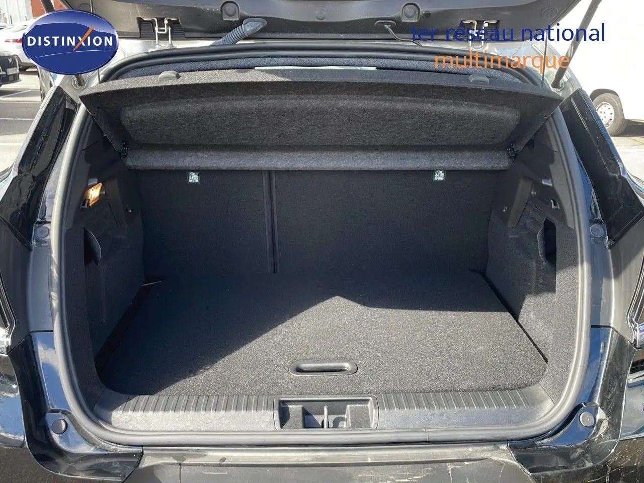 Coffre ouvert vu de l'arrière d'un Renault Captur 2025 noir étoile métal avec toit gris, espace de chargement vide et propre.