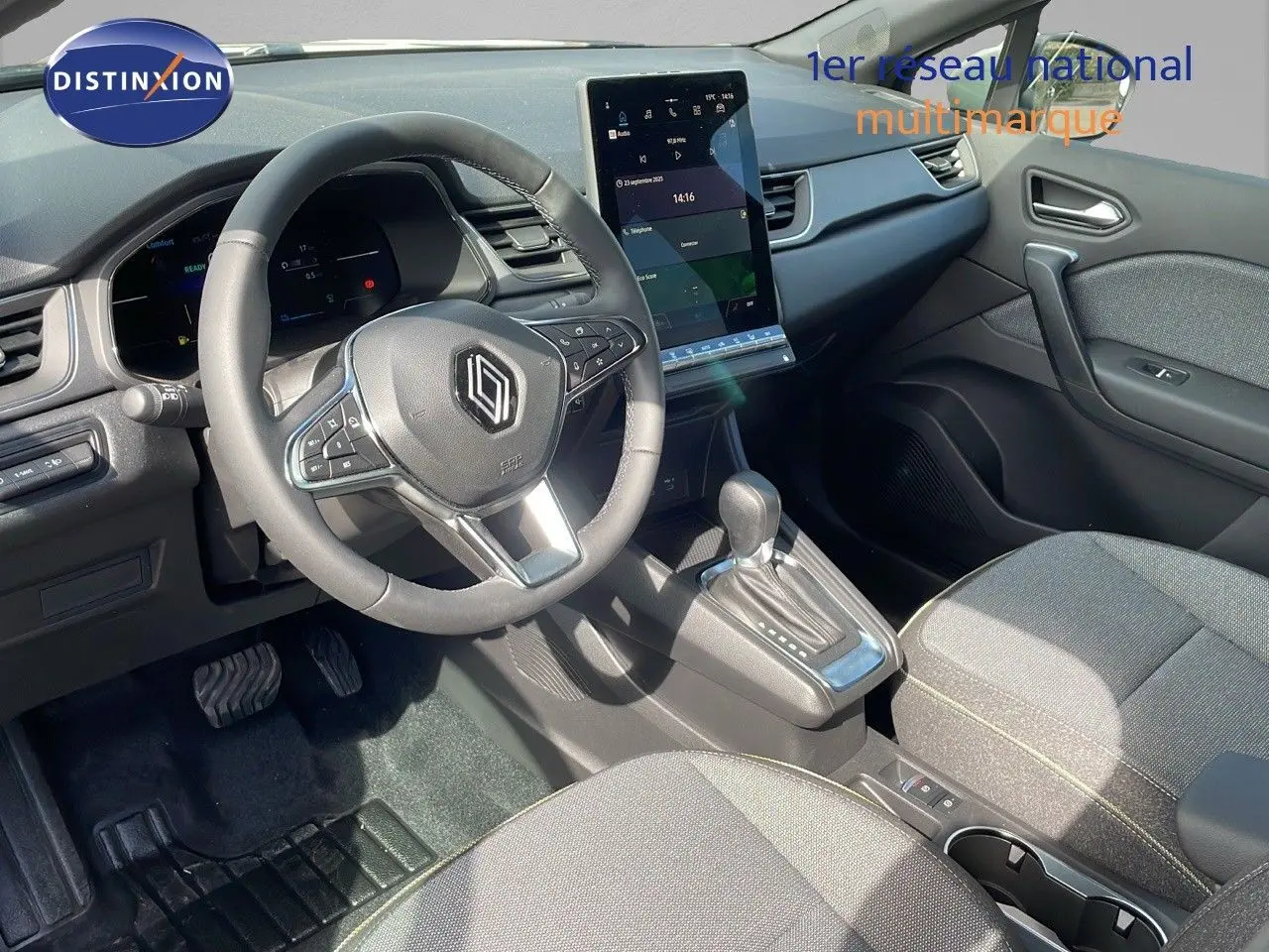 Vue intérieure côté conducteur du Renault Captur 2025, volant multifonction et écran tactile central vertical.