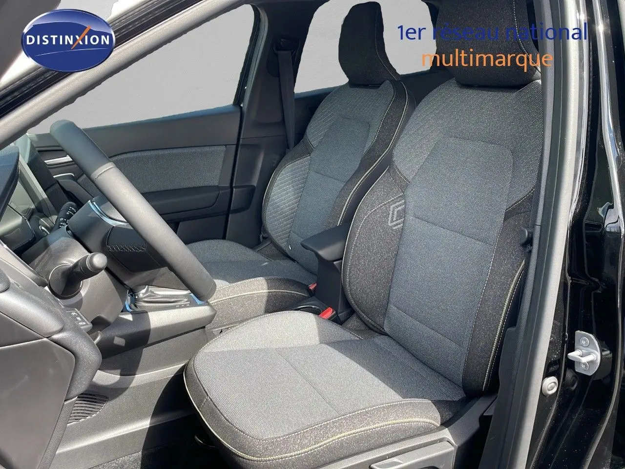 Vue intérieure côté conducteur du Renault Captur 2025 noir étoile métal, sièges tissu gris avec surpiqûres claires.