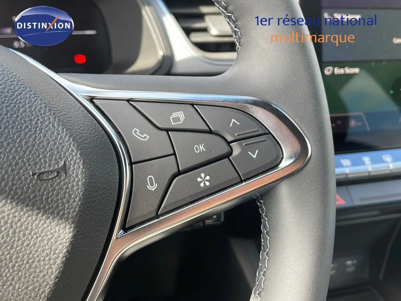 Détail des commandes au volant à droite du Renault Captur 2025, finition noire avec surpiqûres grises.